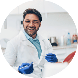 Dentist smiling with tool in hand